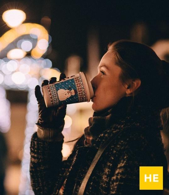 a woman drinking from a disposable cup